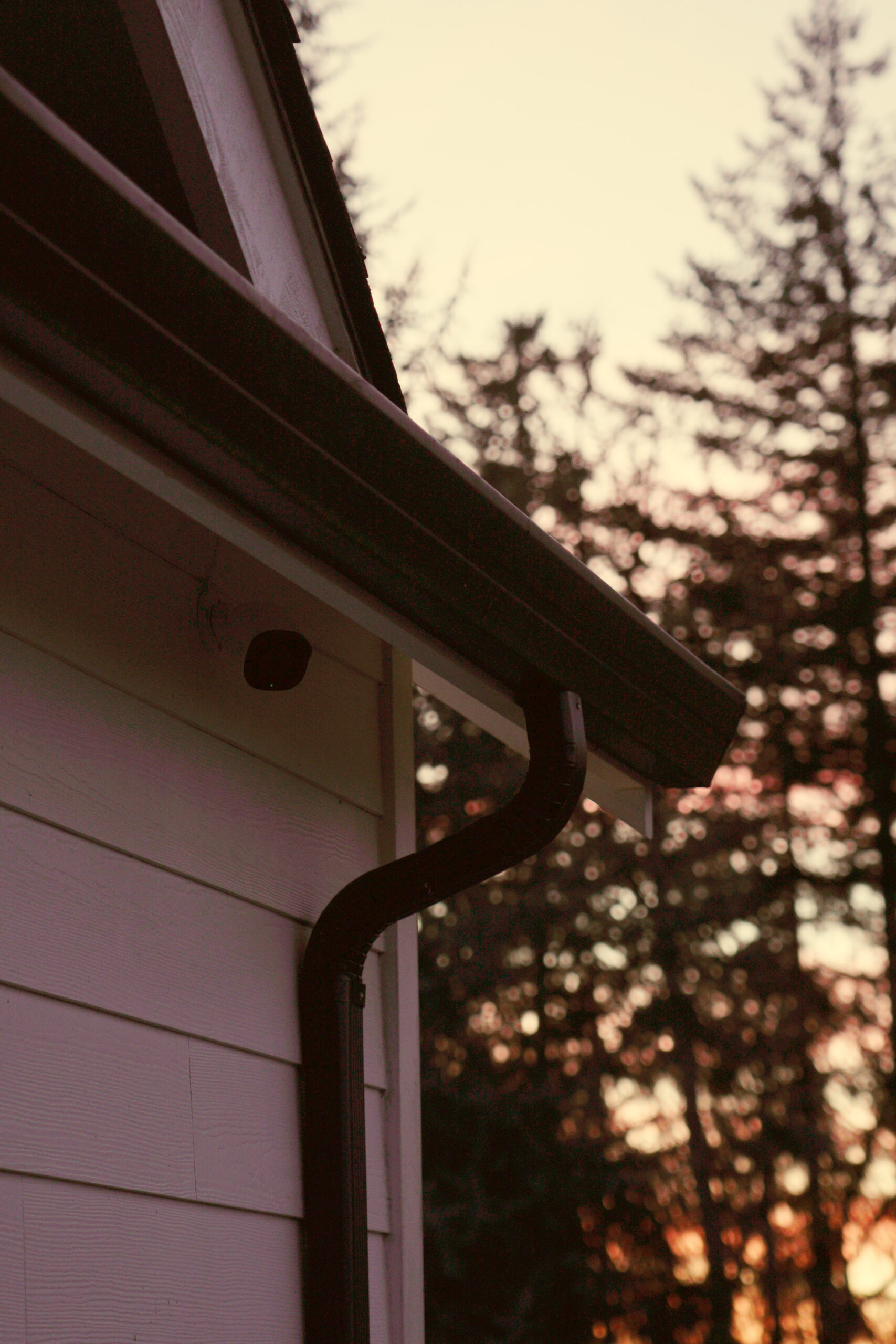 Security camera mounted at corner of home under roofline